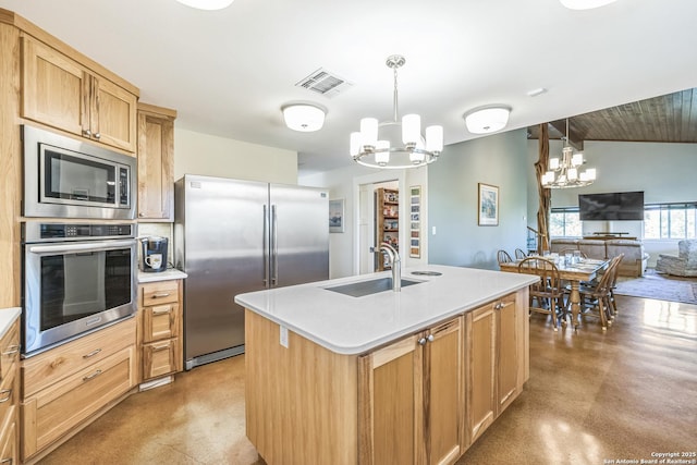 kitchen with a sink, a chandelier, light countertops, appliances with stainless steel finishes, and visible vents