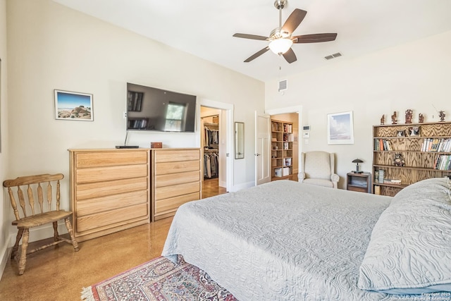 bedroom with a walk in closet, baseboards, visible vents, and a ceiling fan