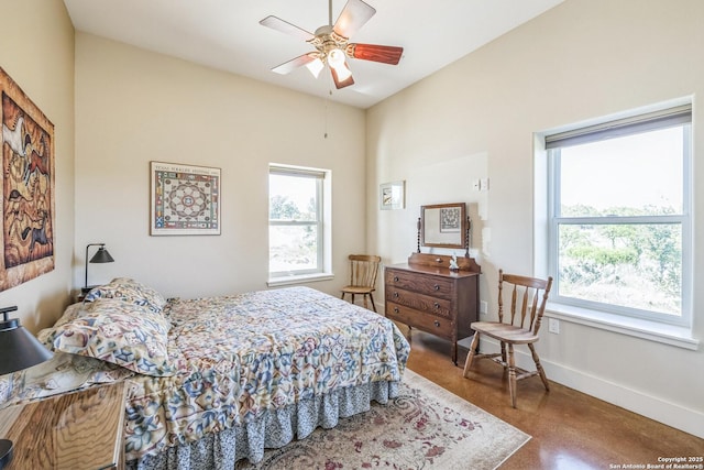 bedroom featuring multiple windows, ceiling fan, and baseboards