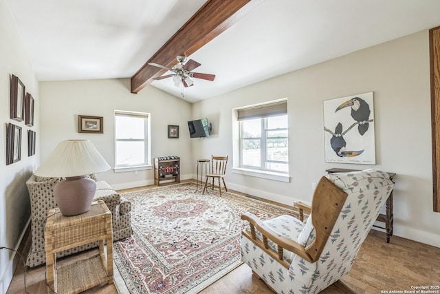 living area featuring ceiling fan, baseboards, vaulted ceiling with beams, and a healthy amount of sunlight