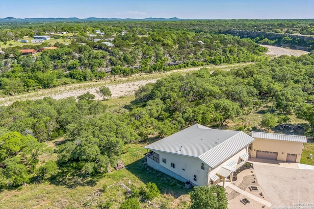drone / aerial view featuring a wooded view