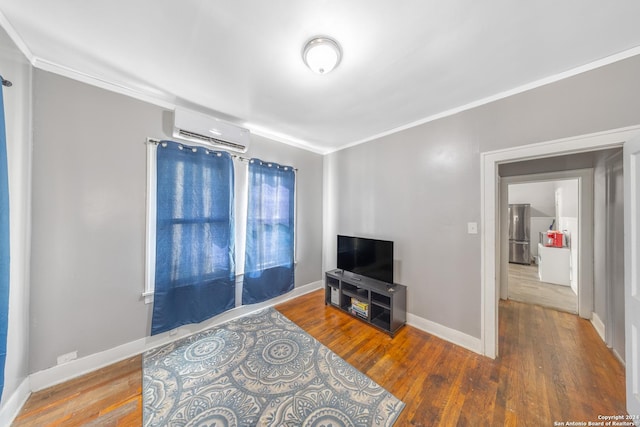 unfurnished living room with baseboards, ornamental molding, wood finished floors, and a wall unit AC