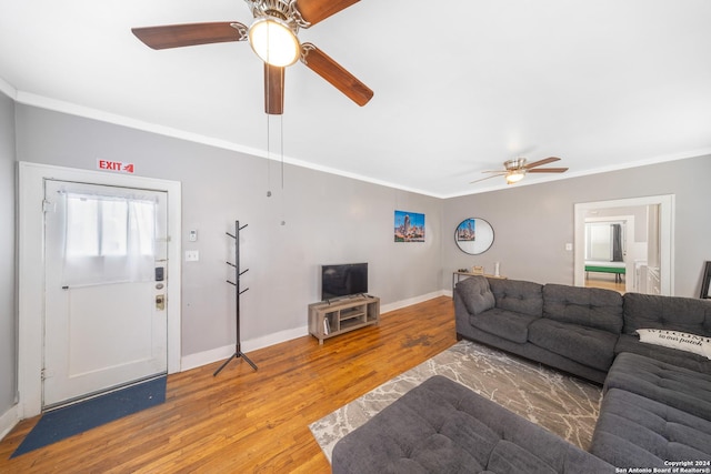 living room with baseboards, wood finished floors, ceiling fan, and crown molding