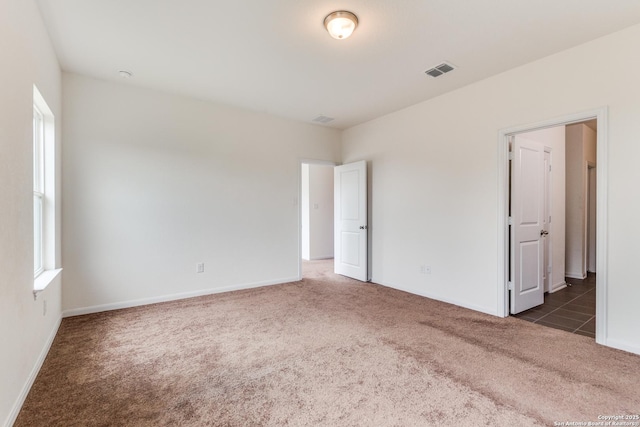 carpeted empty room with baseboards and visible vents