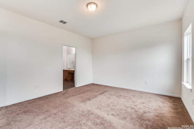 carpeted spare room with baseboards and visible vents