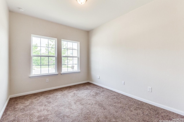 empty room with baseboards and carpet