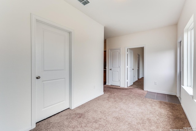 unfurnished bedroom featuring visible vents, carpet, and baseboards