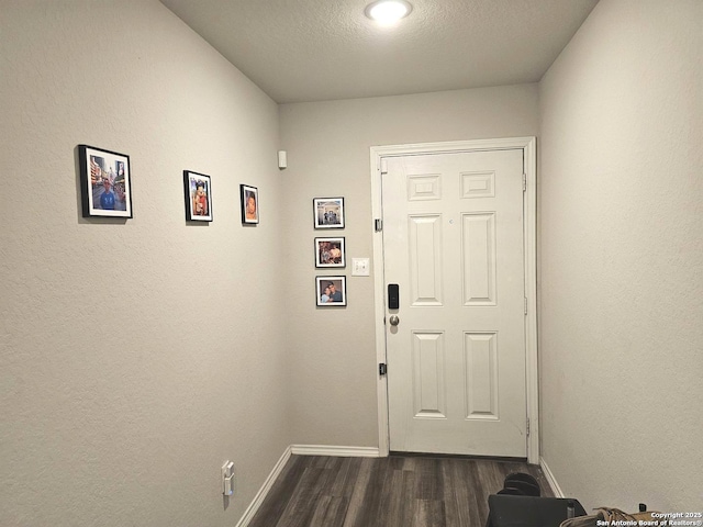 doorway to outside with baseboards and dark wood-type flooring