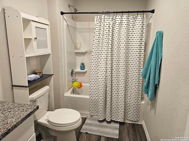 bathroom featuring shower / bath combo, toilet, wood finished floors, a textured wall, and vanity