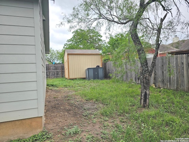 view of yard featuring a fenced backyard, an outbuilding, and a storage shed