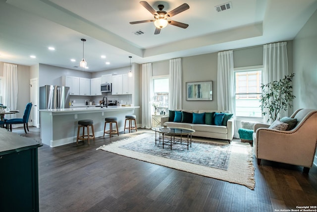 227 Quentin, San Antonio, TX 78201 - living area with a ceiling fan, visible vents, a raised ceiling, and dark wood-style flooring