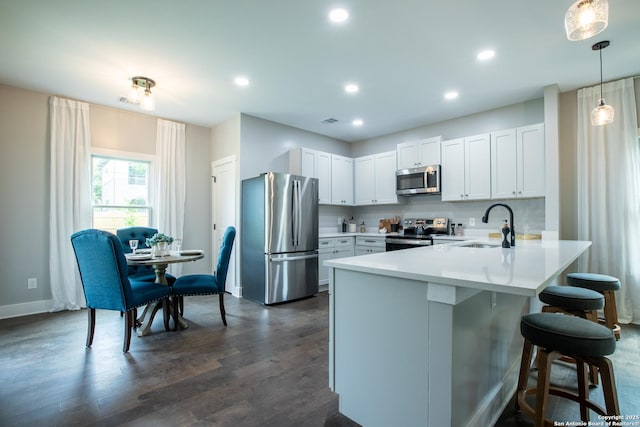 227 Quentin, San Antonio, TX 78201 - kitchen featuring stainless steel appliances, a breakfast bar, a sink, baseboards, and a peninsula