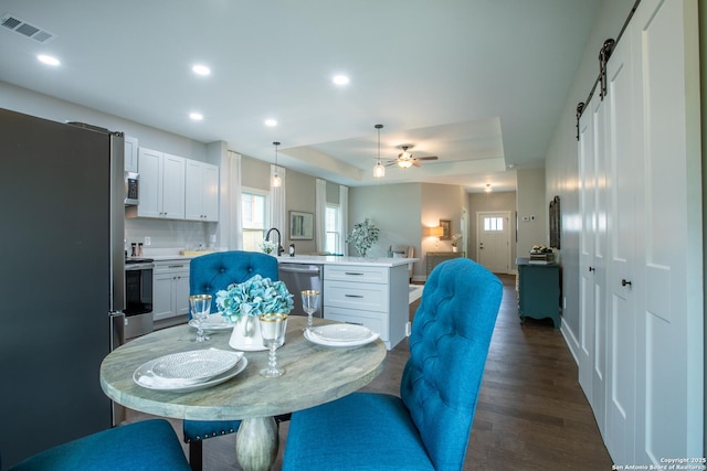 227 Quentin, San Antonio, TX 78201 - dining area with a barn door, a tray ceiling, dark wood finished floors, visible vents, and recessed lighting