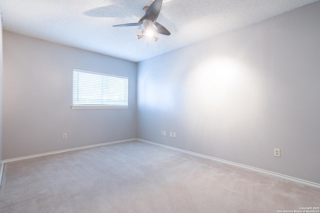 empty room featuring baseboards, carpet floors, a textured ceiling, and ceiling fan