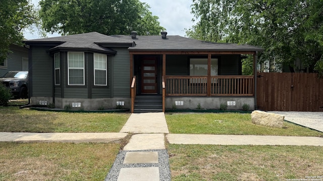 bungalow-style house featuring crawl space, a front lawn, covered porch, and fence