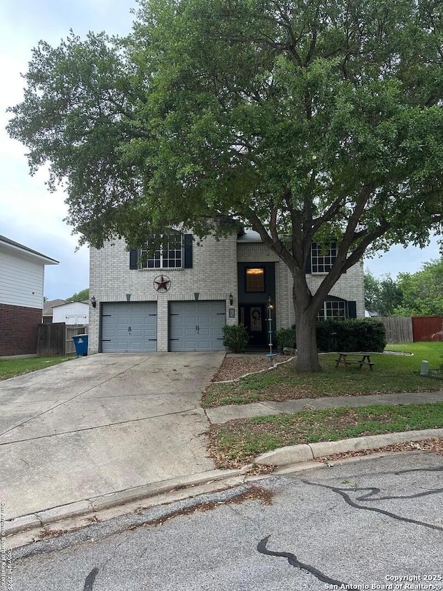 view of front facade featuring an attached garage, driveway, fence, and brick siding