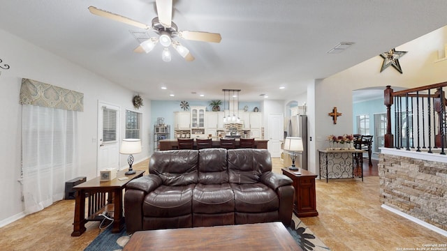 living room featuring ceiling fan, arched walkways, baseboards, visible vents, and recessed lighting