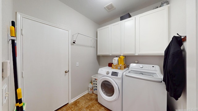washroom featuring baseboards, visible vents, washer and clothes dryer, and cabinet space