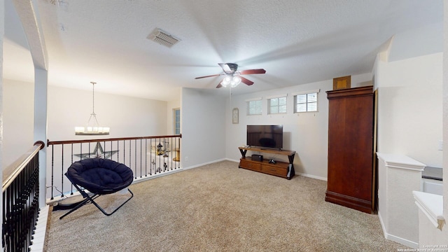 sitting room featuring ceiling fan with notable chandelier, baseboards, visible vents, and carpet floors