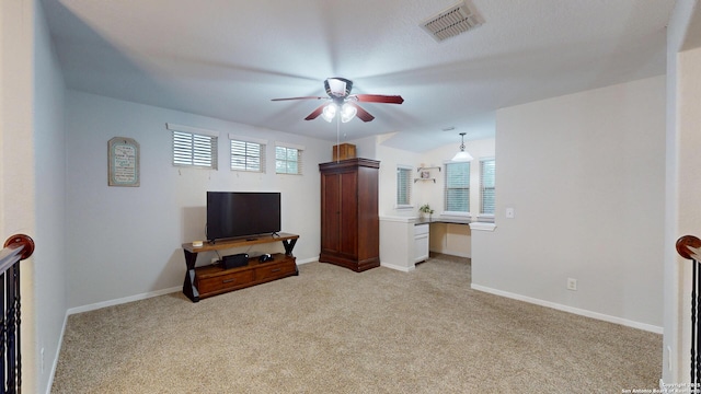 living area with light carpet, a ceiling fan, visible vents, and baseboards