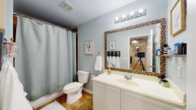 bathroom with vanity, shower / tub combo with curtain, a textured wall, toilet, and visible vents