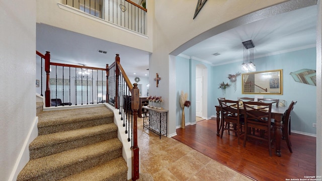 interior space with arched walkways, visible vents, crown molding, and baseboards
