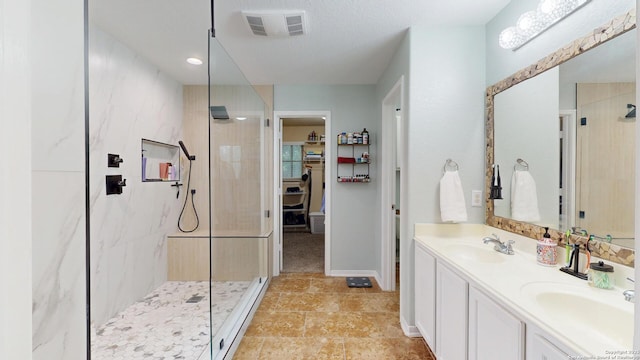 full bathroom with a walk in closet, walk in shower, visible vents, and a sink
