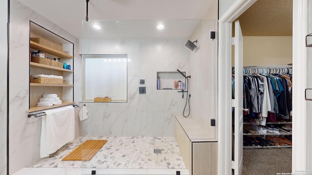 bathroom featuring recessed lighting, a walk in closet, and a tile shower