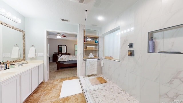ensuite bathroom with a sink, visible vents, walk in shower, ceiling fan, and ensuite bath
