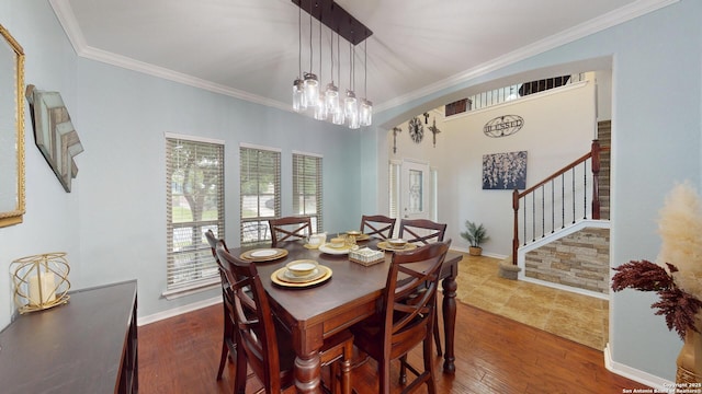 dining room with arched walkways, wood finished floors, crown molding, and stairs