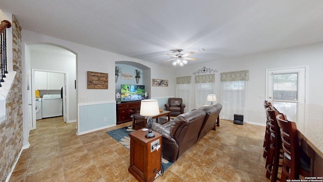 living room featuring washer / dryer, stone finish floor, and ceiling fan