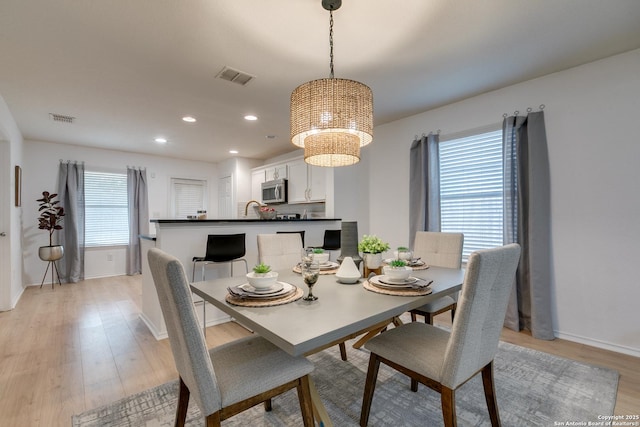 8934 Oakwood, San Antonio, TX 78254 - dining area with baseboards, light wood-style flooring, visible vents, and a chandelier