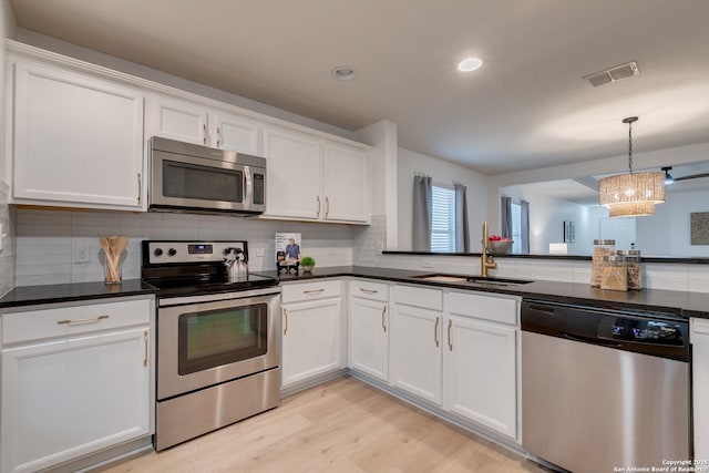 8934 Oakwood, San Antonio, TX 78254 - kitchen with white cabinets, backsplash, appliances with stainless steel finishes, and a sink