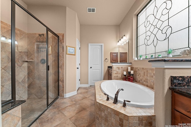 bathroom featuring a shower stall, vanity, a bath, visible vents, and baseboards