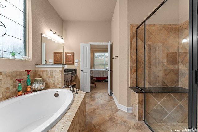 ensuite bathroom with vanity, ensuite bath, a stall shower, baseboards, and a garden tub