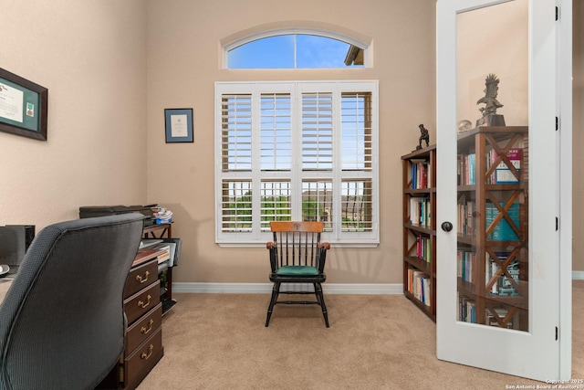office space featuring baseboards, light colored carpet, and plenty of natural light