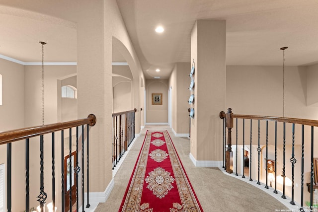 hall with recessed lighting, an upstairs landing, carpet flooring, and arched walkways