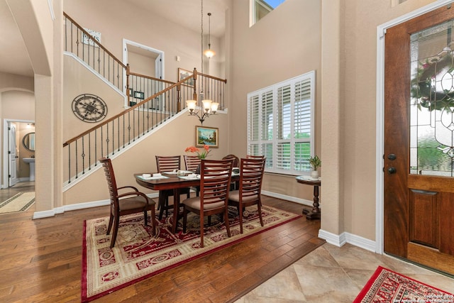 dining room featuring plenty of natural light, a high ceiling, baseboards, and arched walkways