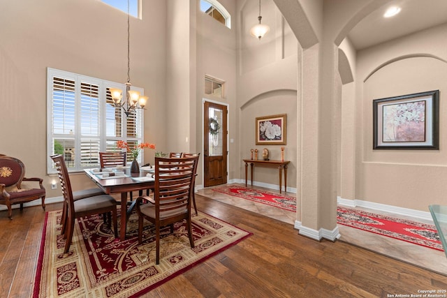 dining area featuring hardwood / wood-style flooring, an inviting chandelier, and plenty of natural light