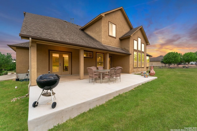 back of property featuring a lawn, a patio, french doors, and roof with shingles