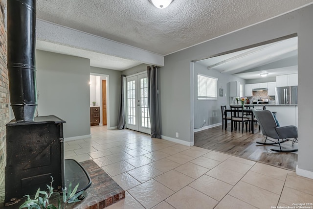 5011 Village Lawn, San Antonio, TX 78218 - living room featuring baseboards, a wood stove, a textured ceiling, and french doors