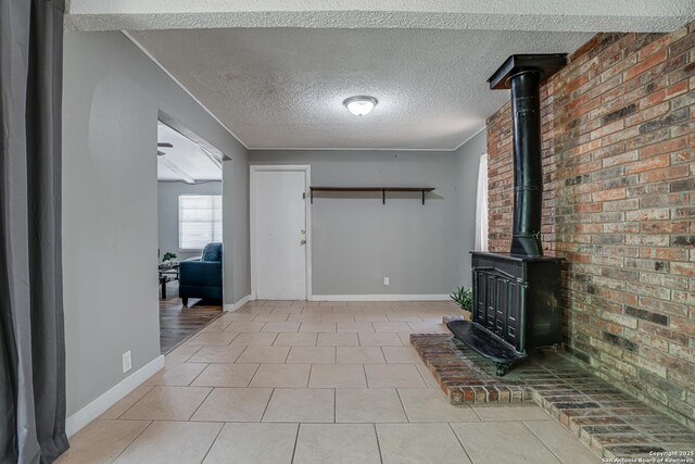 5011 Village Lawn, San Antonio, TX 78218 - unfurnished living room featuring brick wall, a textured ceiling, a wood stove, and tile patterned floors