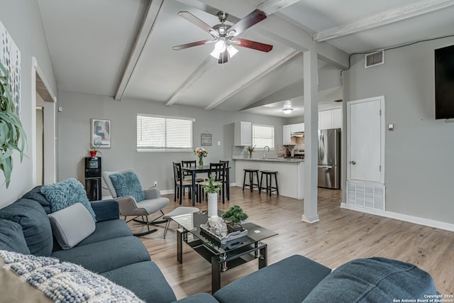 5011 Village Lawn, San Antonio, TX 78218 - living area featuring light wood-type flooring, vaulted ceiling with beams, visible vents, baseboards, and a ceiling fan