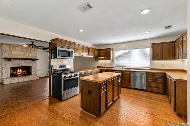 kitchen with butcher block counters, stainless steel appliances, visible vents, and a sink