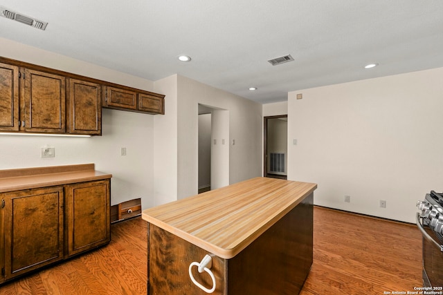 kitchen featuring light wood-style flooring, visible vents, and stainless steel gas range