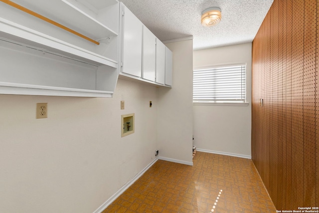 laundry area featuring a textured ceiling, baseboards, washer hookup, cabinet space, and electric dryer hookup