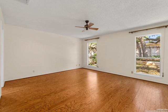 spare room with a ceiling fan, wood finished floors, and a textured ceiling