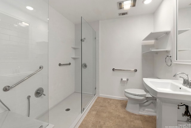bathroom featuring tile patterned floors, toilet, a stall shower, baseboards, and visible vents