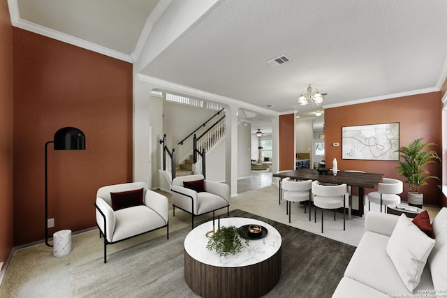 carpeted living room with crown molding, stairs, an inviting chandelier, baseboards, and visible vents