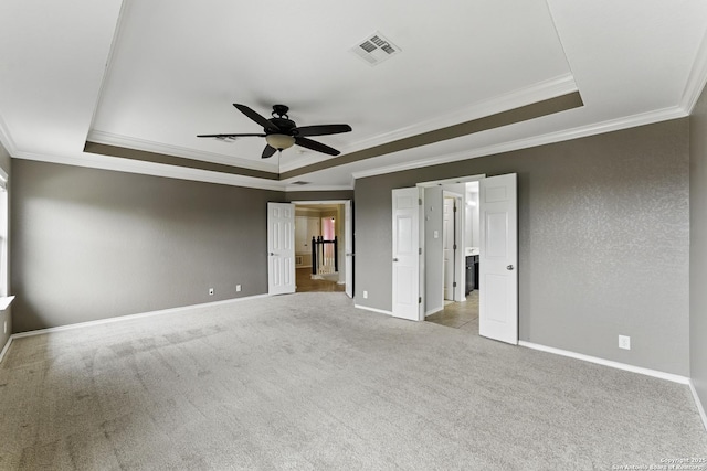 unfurnished bedroom featuring a raised ceiling, crown molding, and baseboards